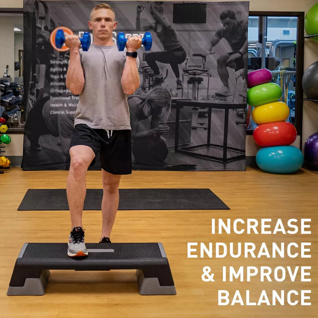 Person exercising with dumbbells on a step platform in a gym setting