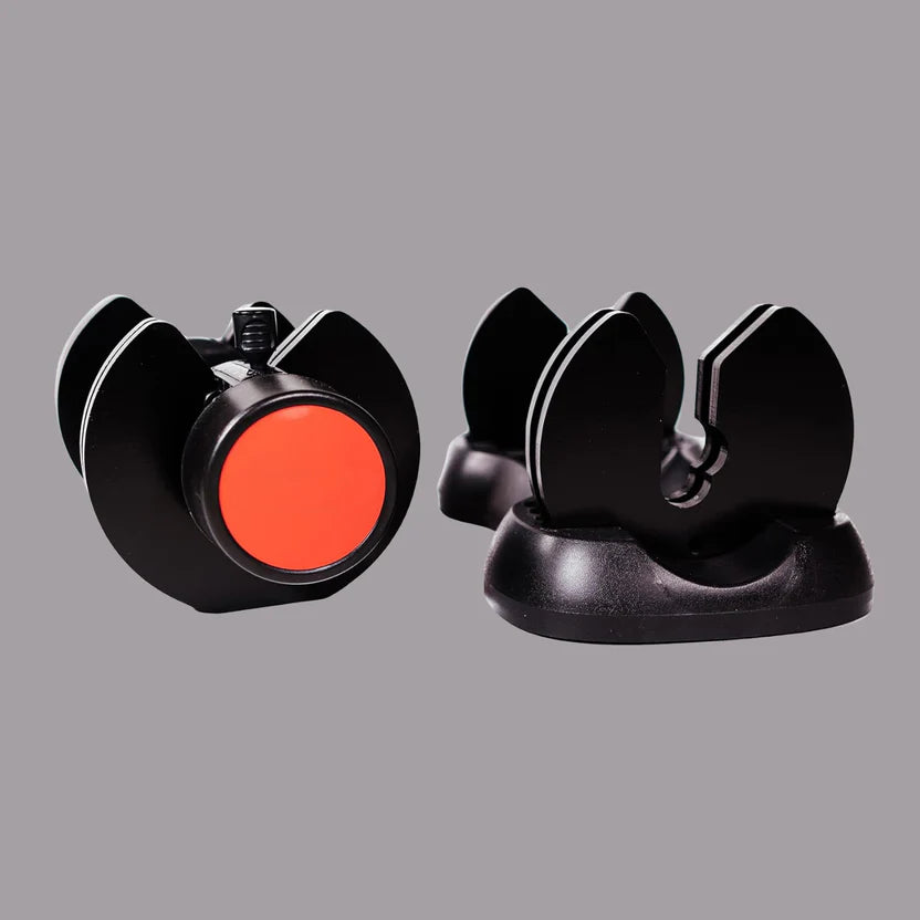 Black and red camera lens cap with a gray background