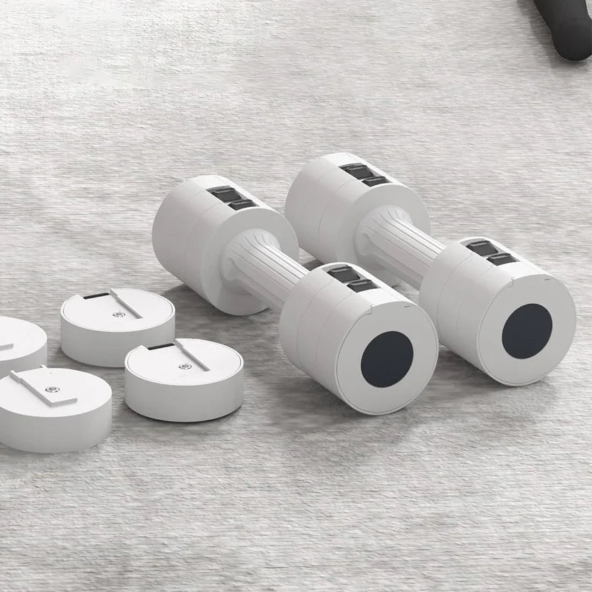 Set of white dumbbells with black weight plates on a gray surface
