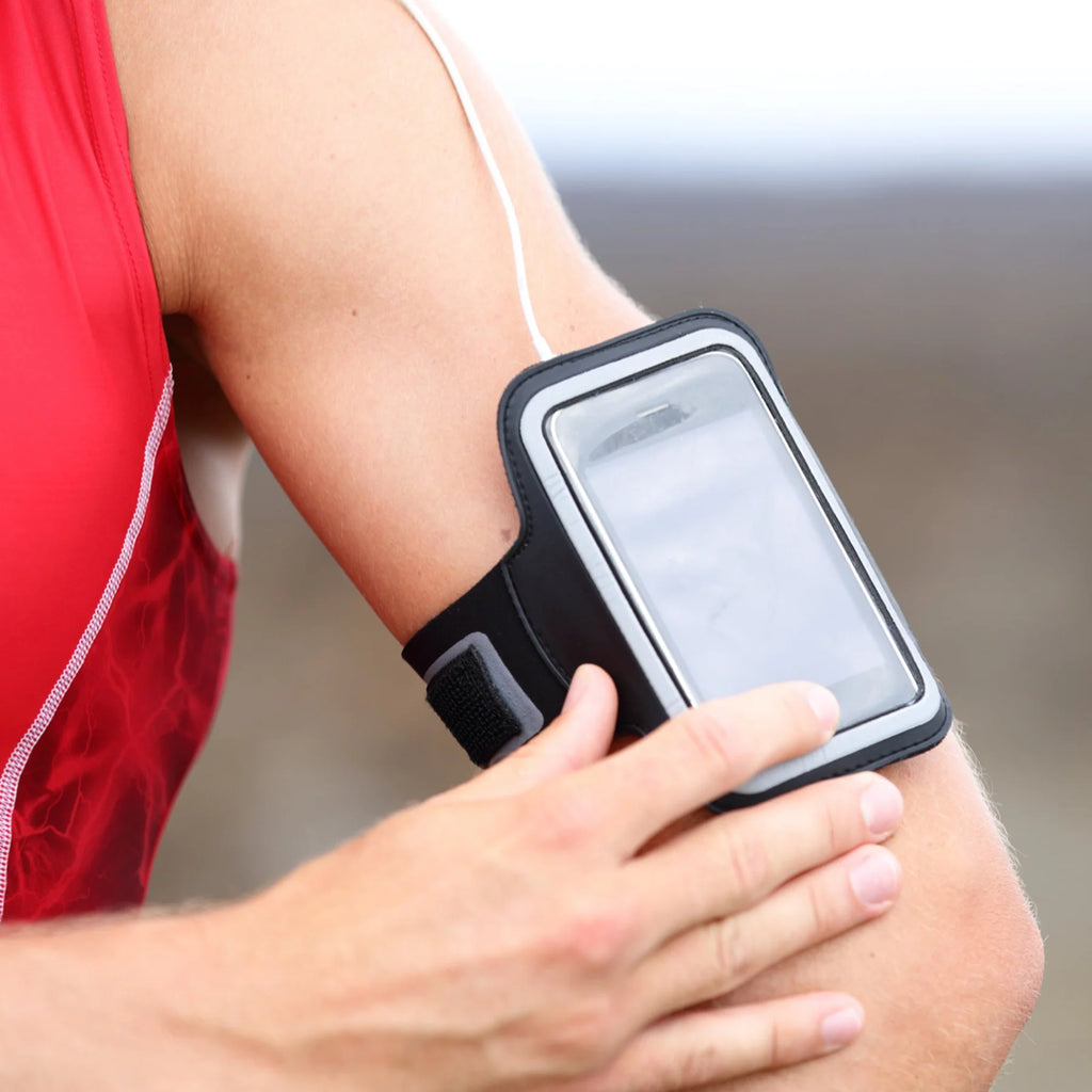 Person wearing a black arm band with a phone on an arm, blurred background